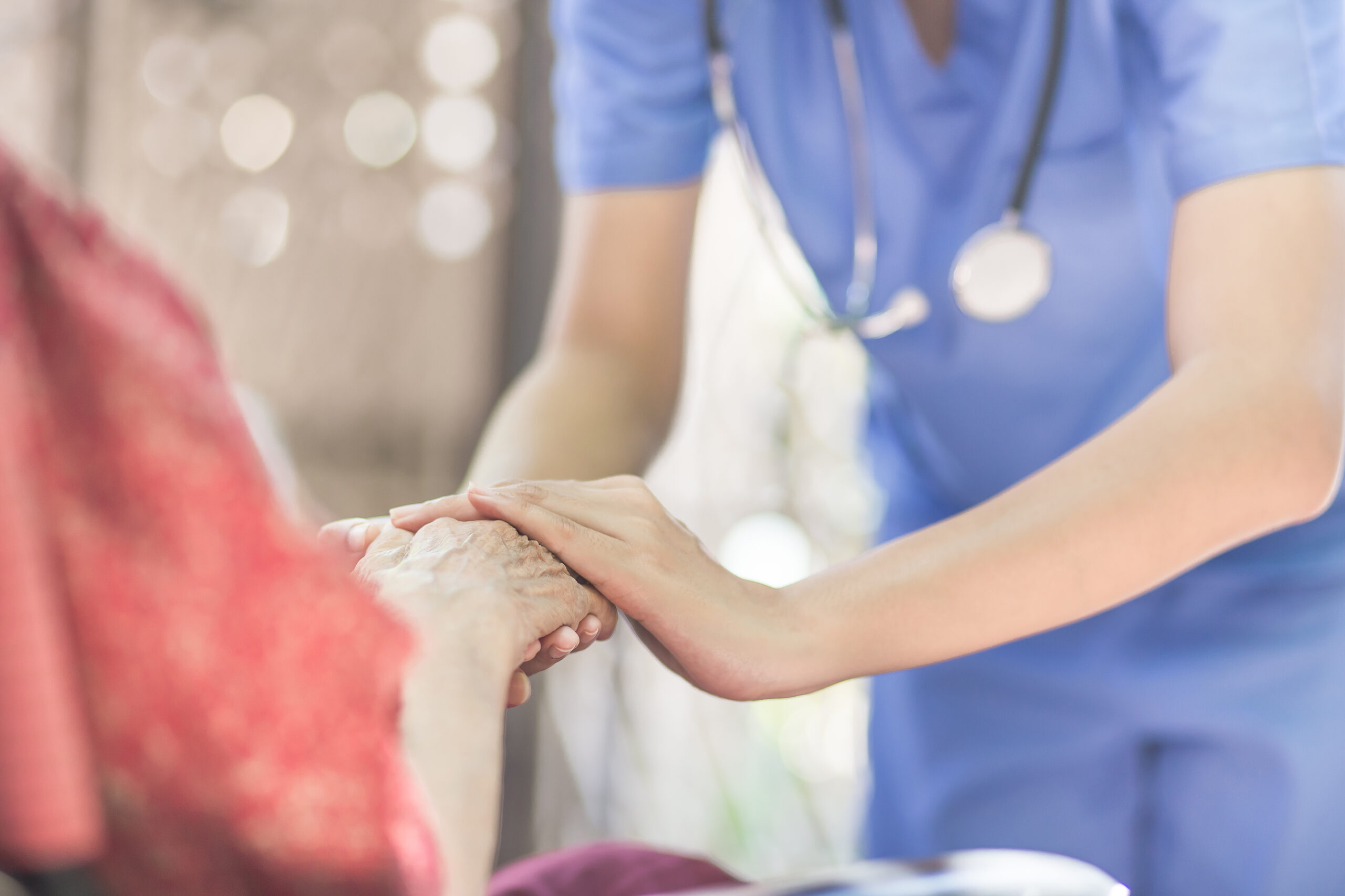 Holding hand of elderly woman in hospice care
