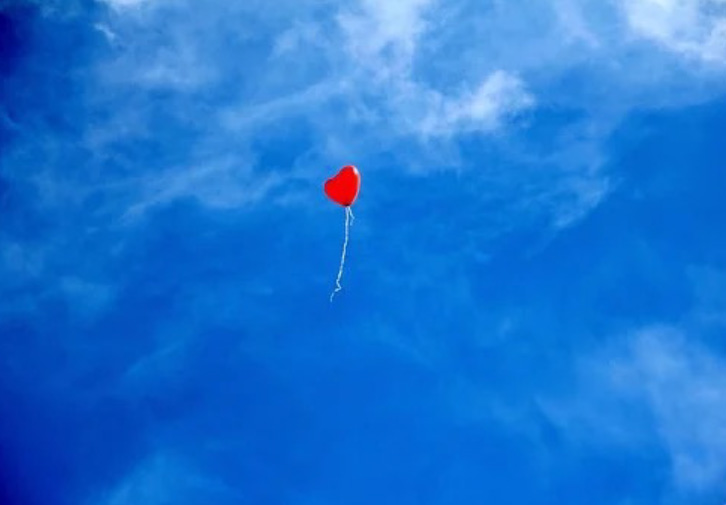 heart shaped balloon floating in sky
