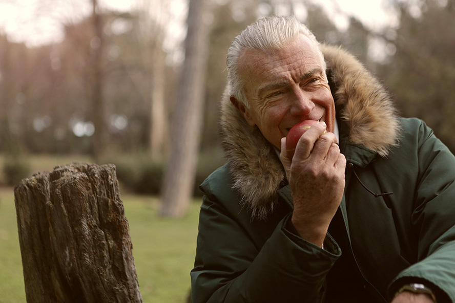Senior man eating healthy apple