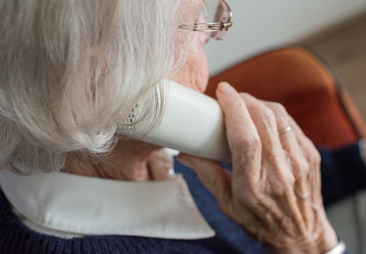 elderly woman on phone with medicare scammer